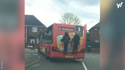 Shocking video shows two school boys risking their lives clinging onto the back of a moving bus