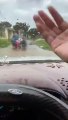 Người đàn ông lái ô tô ngăn dòng nước lũ để bà con lái xe máy đi qua an toàn