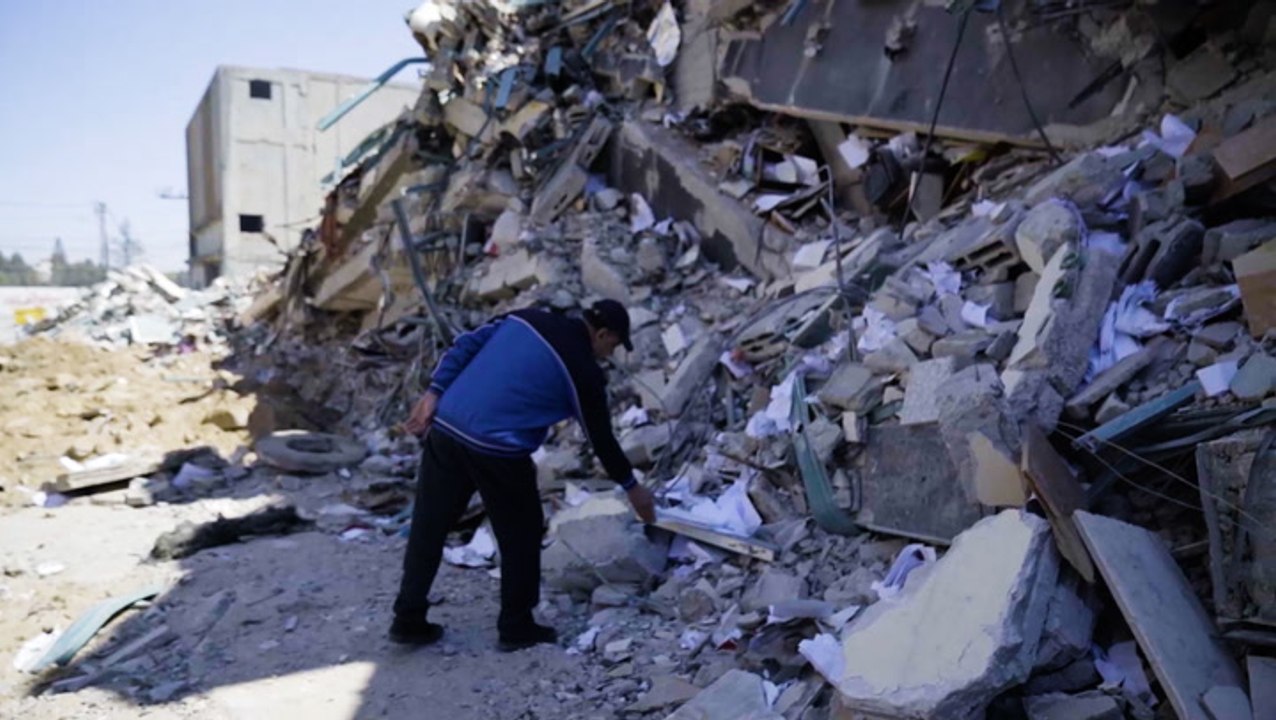 Owner of a Gaza high-rise digs through the remains of his building after it's destroyed by Israel