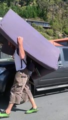 Man Carrying Couch Takes up a Lane