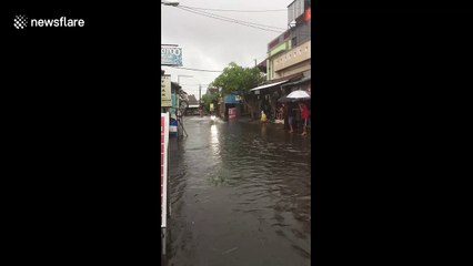 Using a scooter these Indonesians are waterskiing in the flood-hit town