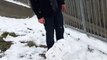 Man Throwing a Large Snowball into Water