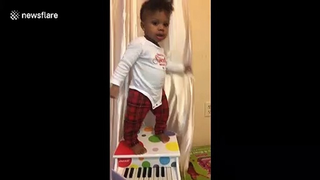 Young pianist takes a tumble when trying to play with toy instrument
