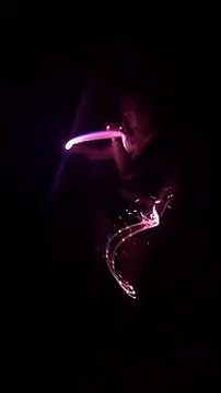 Une fille danse avec un fils LED lumineux dans le noir et c'est super cool !