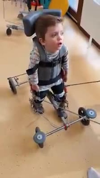 Jules fait ses premiers pas à l'aide d'un déambulateur