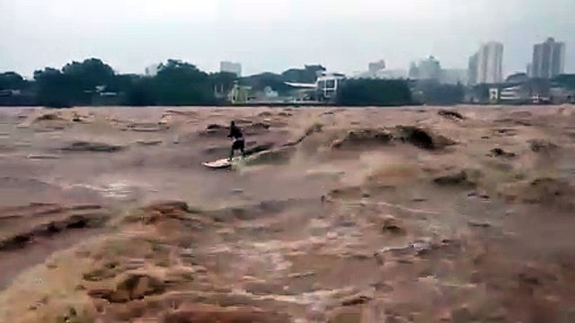 Ce surfeur prend la vague sur un fleuve en crue... risqué