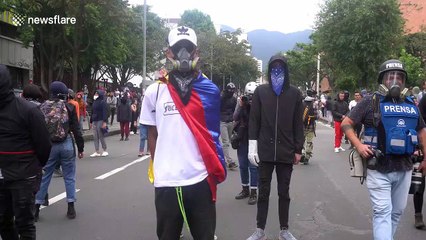 Riot police clash with masked protesters in Bogota