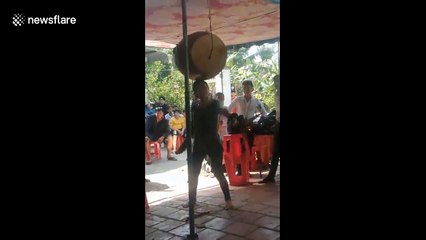 Vietnamese woman able to play barrel-sized drum that's balanced on her head