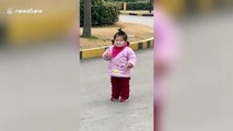 Hilarious moment toddler tries to eat biscuit through her face mask in China