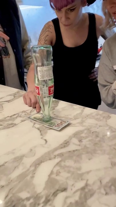 Défi du jour : retirer ce billet sans toucher ou faire tomber la bouteille