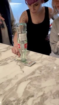 Défi du jour : retirer ce billet sans toucher ou faire tomber la bouteille