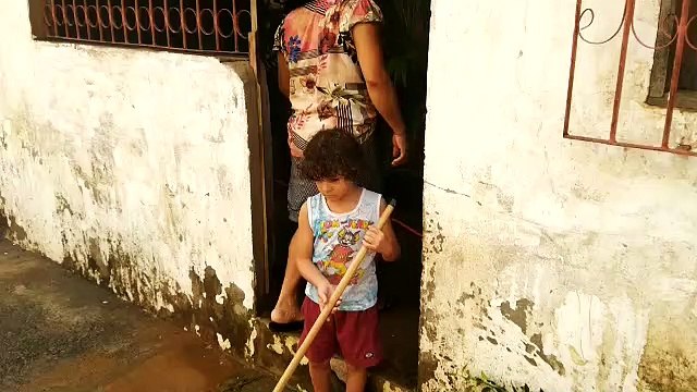 Neto de cinco anos ajuda avós a limpar casa tomada por água