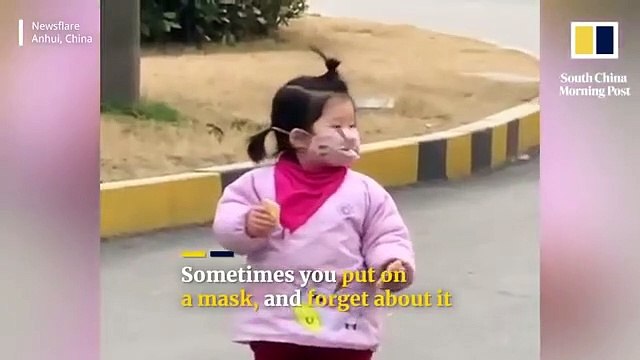 Cette petite fille veut manger son biscuit mais n'a pas enlevé son masque