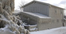 Ces maisons au bord d'un lac ont été entièrement recouvertes de glace