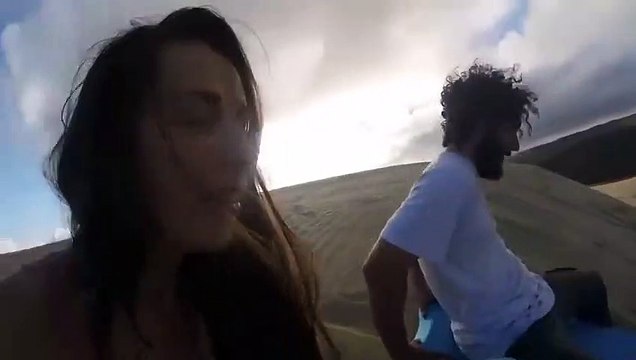 Descendre une dune de sable sur un surf : attention le sable dans les dents