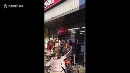Huge queues outside Beijing supermarket as face masks go back on sale