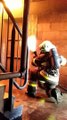 Deux pompiers forment un bouclier d'eau pour se protéger contre des flammes