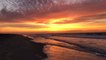 Sunrise glows orange along Fire Island's coast
