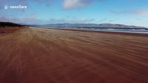 Dramatic drone footage captures gusts of wind blowing sand over UK beach