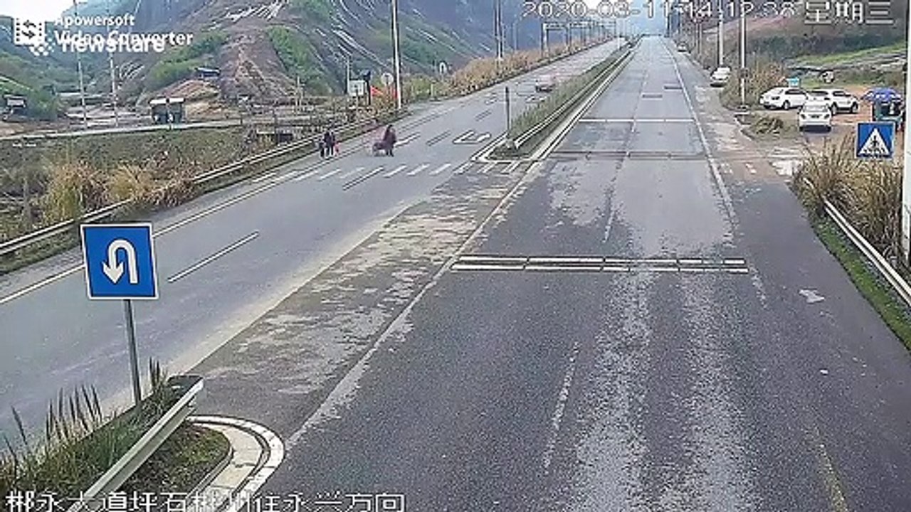 Distracted motorist in China crashes into pedestrian walking across road with handcart