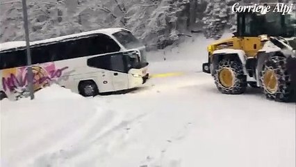 The tourist bus in the Zoldo valley towed on the snowy curves