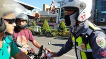 Philippine police stop and confiscate licenses from motorcyclists who are not wearing face masks