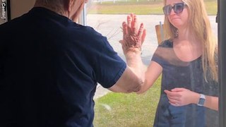 Woman surprises quarantined grandpa with engagement news through nursing home window