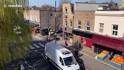 London police officer instructs customer to wait outside bakery while another is served during lockdown