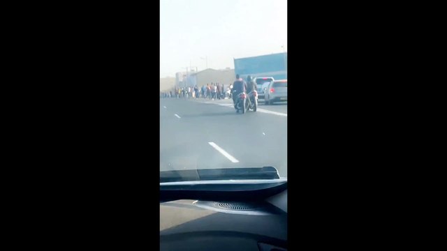 Des centaines de personnes marchent sur l'autoroute en espérant arriver avant 20h