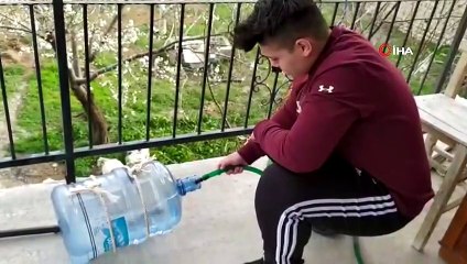 Genç kadın halterci, damacanadan yaptığı halter barlarıyla çalışıyor