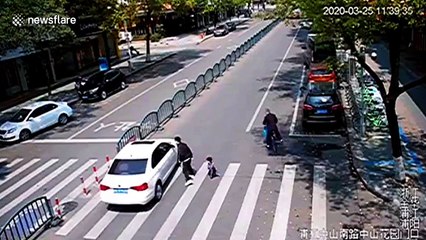 Chinese father's quick reactions save son from being run over by car at crossing