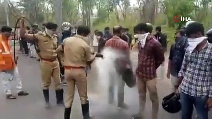 Hindistan’da göçmen işçiler kimyasal madde sıkan hortumla dezenfekte edildi