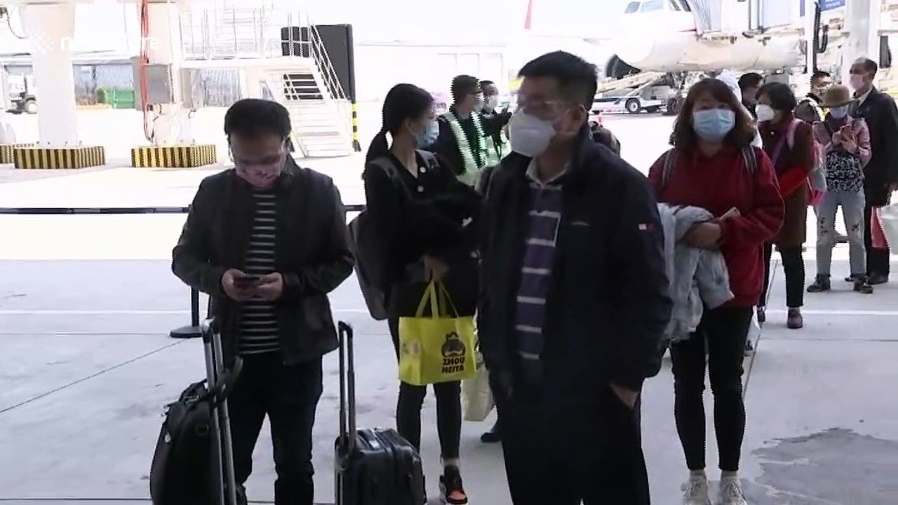 Passengers from Wuhan show QR code for checks upon arrival at airport