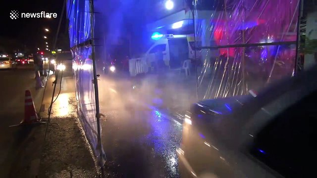 Sanitising tunnel sprays vehicles passing through Thailand city