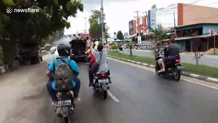 Police spray disinfectant with water cannon onto Indonesian roads