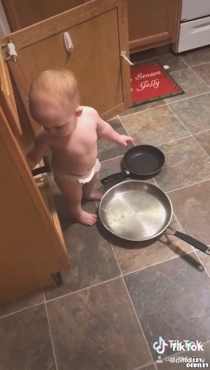 Un bébé sur le point de cuisiner essaye de ne pas rire