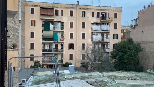 Vecinos de un barrio de Roma salen a aplaudir desde sus balcones