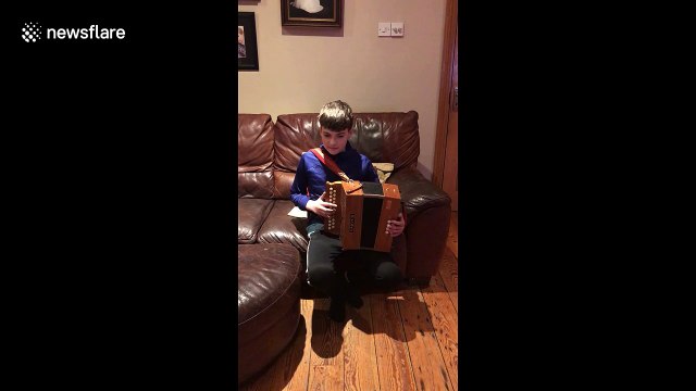 Dog sings along to boy playing accordion!