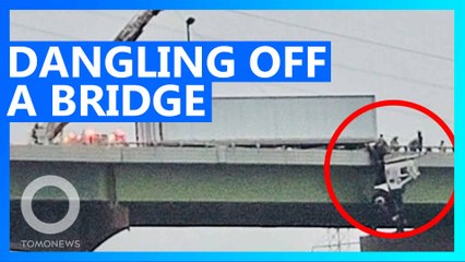 Strong winds leave truck driver dangling off a bridge