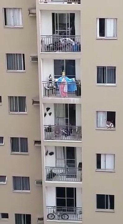 Idosa presta homenagem à Nossa Senhora da Penha da varanda de casa e vizinhos acompanham