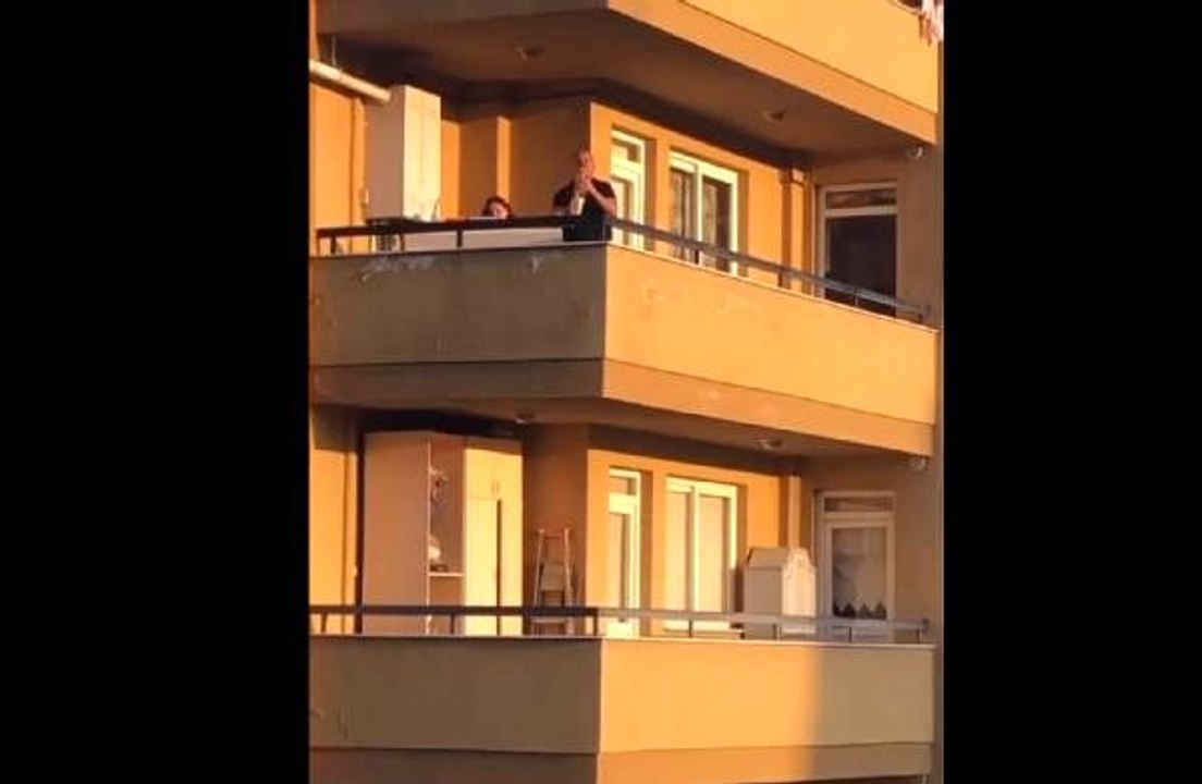 Balkondaki çiftten saksafon, piyano ve kemanla konser