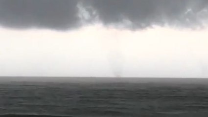 Waterspout swirls in the distance