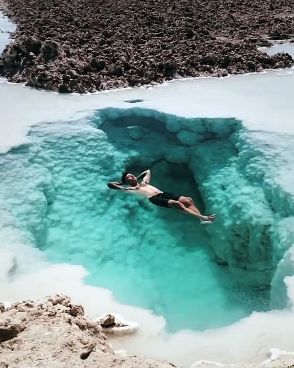 Egypte : ce touriste nage dans ce trou d’eau d’un bleu magnifique au milieu d’un paysage de désert mystérieux.