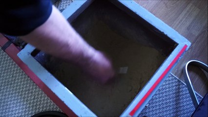 Breaking up and loosening hardened sand with an iron nail and a chisel