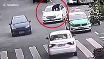 Dog spotted balancing on roof of car driving along road in China