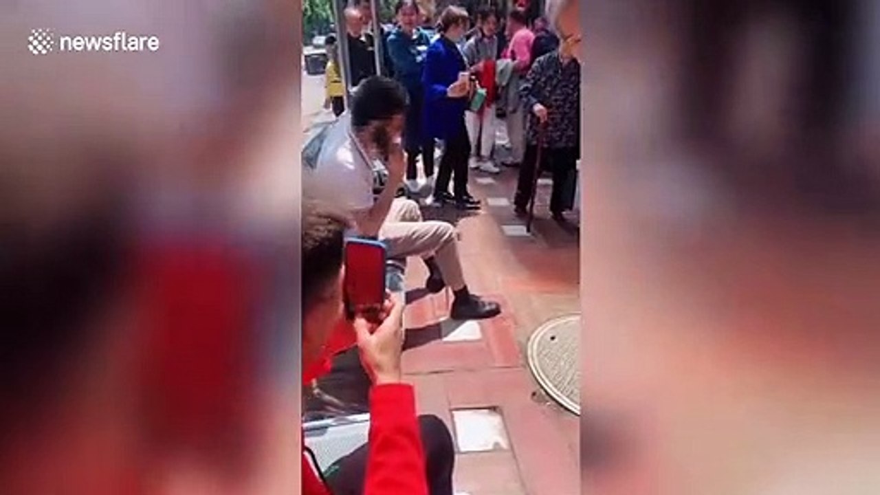 Snake climbs up Chinese man's trousers as he rests on outdoor chair