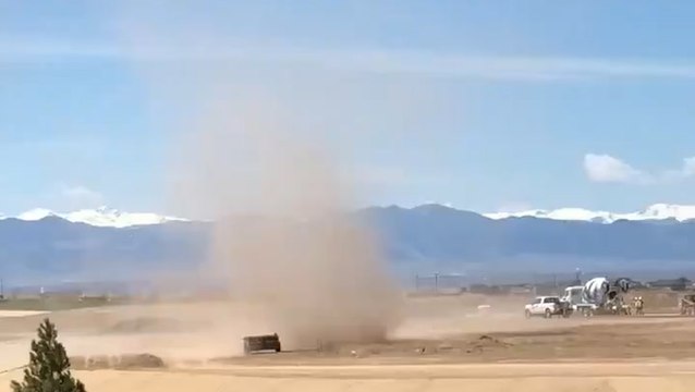 Dust devil swirls over an open field