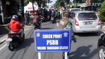 Petugas Satpol PP memberikan sosialisasi penerapan PSBB kepada pengendara di Jalan Daan Mogot, Tangerang.