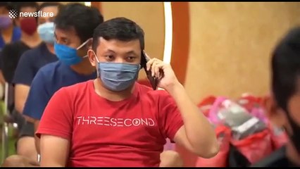Indonesian care workers wear protective gear while taking turns to cut each other's hair during COVID-19 pandemic