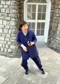 Cet homme réalise un mime très réussi qui consiste à attraper une bouteille qui lui échappe des mains.